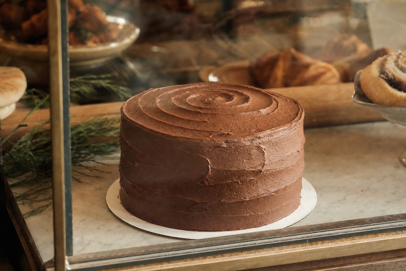 Frosted 8-inch chocolate cake in the bakery display case